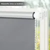 Close-up of a gray roller blind attached to a window frame with a white clamp mechanism. Produktbild-Vorschau