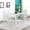 A dining set with a white table and four white chairs in a room with a bookshelf and wall art. Podgląd zdjęcia produktu