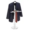 A white valet stand holding a navy blue suit jacket, a red patterned tie, and a brown wallet. Produktbild-Vorschau
