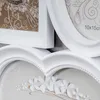 A close-up view of several white photo frames, some with decorative elements inside. Produktbild-Vorschau