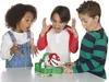 Three children are gathered around a table, looking with surprise at a Super Mario Piranha Plant toy. Produktbild-Vorschau
