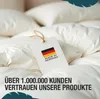 A close-up of a white duvet with a tag showing the German flag and 'Made in Germany'. Produktbild-Vorschau