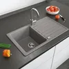 A kitchen sink with a faucet, a drying rack, and some vegetables on a countertop. Náhled obrázku produktu
