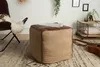 A living room scene with a pouf in the foreground. Produktbild-Vorschau