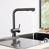 A black kitchen faucet with water running into a black sink. Produktbild-Vorschau