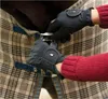 A close-up shot of hands wearing black gloves fastening a blanket on a horse. Anteprima dell’immagine prodotto
