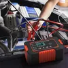 A person is using a car battery charger in the engine bay of a car. Produktbild-Vorschau