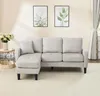 A beige sectional sofa with a chaise lounge is shown in a living room setting with two framed botanical prints on the wall and a side table with a vase of flowers. Anteprima dell’immagine prodotto
