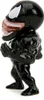 A side view of a small, black Venom figurine with its mouth open and tongue out, standing on a white background. Produktbild-Vorschau