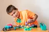 A young boy is focused on assembling an electronic science kit on a wooden table. Podgląd zdjęcia produktu