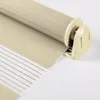 A close-up view of a beige and white roller blind, showing the fabric texture and the roller mechanism. Produktbild-Vorschau