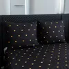 A close-up view of a bed with black bedding featuring a pattern of golden hearts. Produktbild-Vorschau