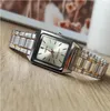 A close-up shot of a Casio watch with a silver and gold band and a white face, resting on a wooden surface. Podgląd zdjęcia produktu