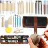 A collection of pottery sculpting tools laid out and a hand using a tool on clay. Produktbild-Vorschau