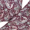 A close-up view of a burgundy fabric with a paisley pattern in various colors. Produktbild-Vorschau