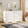 A modern white dresser with four drawers is shown in a well-lit room, next to a window with beige curtains. Decorative items and artwork adorn the top of the dresser and the wall behind it. Anteprima dell’immagine prodotto