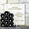 A black hexagonal wine rack filled with wine bottles, set against a stone wall background. Produktbild-Vorschau