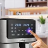 Close-up of an air fryer's control panel with a finger touching a button, set in a bright kitchen. Voir les images du produit