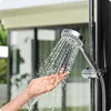 A hand is being tested under a shower head with water spraying from it. Produktbild-Vorschau