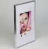A silver picture frame with a mat and a photo of a woman holding macarons. Produktbild-Vorschau