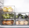 Several clear plastic storage containers filled with various fruits and vegetables are stacked inside a refrigerator. Náhled obrázku produktu