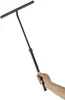 A hand holding a black floor squeegee with a telescopic handle against a white background. Podgląd zdjęcia produktu