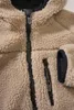 A close-up view of a beige teddy fleece jacket with black zippers and trim. Produktbild-Vorschau