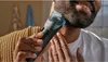 A man is trimming his beard with a Philips beard trimmer. Anteprima dell’immagine prodotto