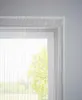 A close-up view of a white string curtain hanging in front of a window, with a blurred green tree visible outside. Produktbild-Vorschau