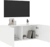 A white TV cabinet with two open compartments, one containing books and a plant, and the other empty. A black TV is mounted on the wall above the cabinet. Produktbild-Vorschau