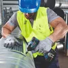 A construction worker wearing a hard hat and safety vest is using a Bosch cordless impact driver to attach a vent to a large metal duct. The worker is wearing gloves and is focused on the task. Produktbild-Vorschau