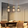 A dining table with chairs and pendant lights hanging above. Anteprima dell’immagine prodotto