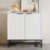 A white two-door cabinet with a metal base and handles is shown in a room setting. Produktbild-Vorschau