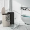 A modern bathroom with a bathtub, a shelf with toiletries, and two laundry baskets. Produktbild-Vorschau