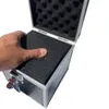 A hand is pressing down on the foam lining inside an open aluminum case. Produktbild-Vorschau