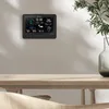 A digital weather station is mounted on a wall above a wooden table. Produktbild-Vorschau