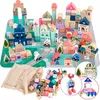 A collection of wooden building blocks arranged to form a city scene, including buildings, vehicles, and a play mat, with a bag of loose blocks in the foreground. Náhled obrázku produktu
