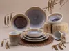 A collection of stoneware dishes and mugs arranged on a neutral background with decorative branches. Náhľad obrázku produktu