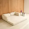 A beige sofa is shown in a room with a wooden wall. Anteprima dell’immagine prodotto