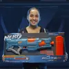 A young girl is holding a large box containing a Nerf Elite 2.0 Turbine CS-18 blaster. Anteprima dell’immagine prodotto