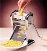 A hand is using a pasta maker to create gnocchi, which are falling into a bowl. Anteprima dell’immagine prodotto