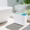 A white recycling bin with three compartments sits next to a white bathtub in a bright, sunlit room with a large window overlooking greenery. Náhľad obrázku produktu