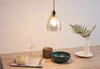 A pendant light hangs above a table set with a wine glass, a decorative bowl, a small vase with greenery, and a tray with decorative items. Anteprima dell’immagine prodotto