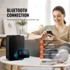 A woman is using a smartphone to control a black diffuser, which is placed on a table. Produktbild-Vorschau