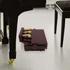 A close-up view of a piano pedal extender bank placed on the floor next to a grand piano. Náhled obrázku produktu