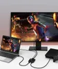 A laptop, a game console, and a large monitor are connected via a splitter switch, displaying a video game. Produktbild-Vorschau