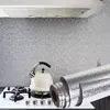 A kitchen scene with a stovetop, kettle, and a roll of foil. Produktbild-Vorschau