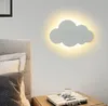 A cloud-shaped wall lamp illuminates a bedroom wall above a nightstand with a book and a cup of coffee. Produktbild-Vorschau