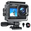 A black action camera with a waterproof case, mounted on a tripod adapter, with a small microphone and a remote control in the foreground. Produktbild-Vorschau