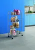 A metal storage trolley filled with various food items and containers, placed on a tiled floor in front of a bright blue wall and kitchen cabinets. Produktbild-Vorschau
